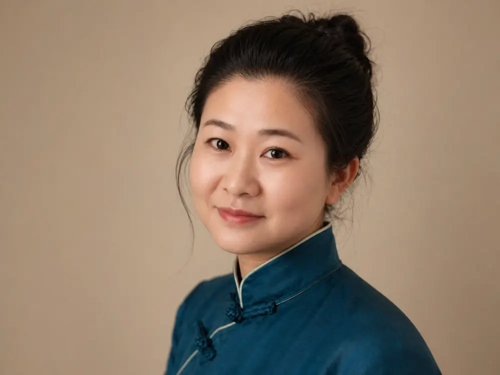 Lee, founder of Tales with Lee, in a traditional blue Chinese jacket